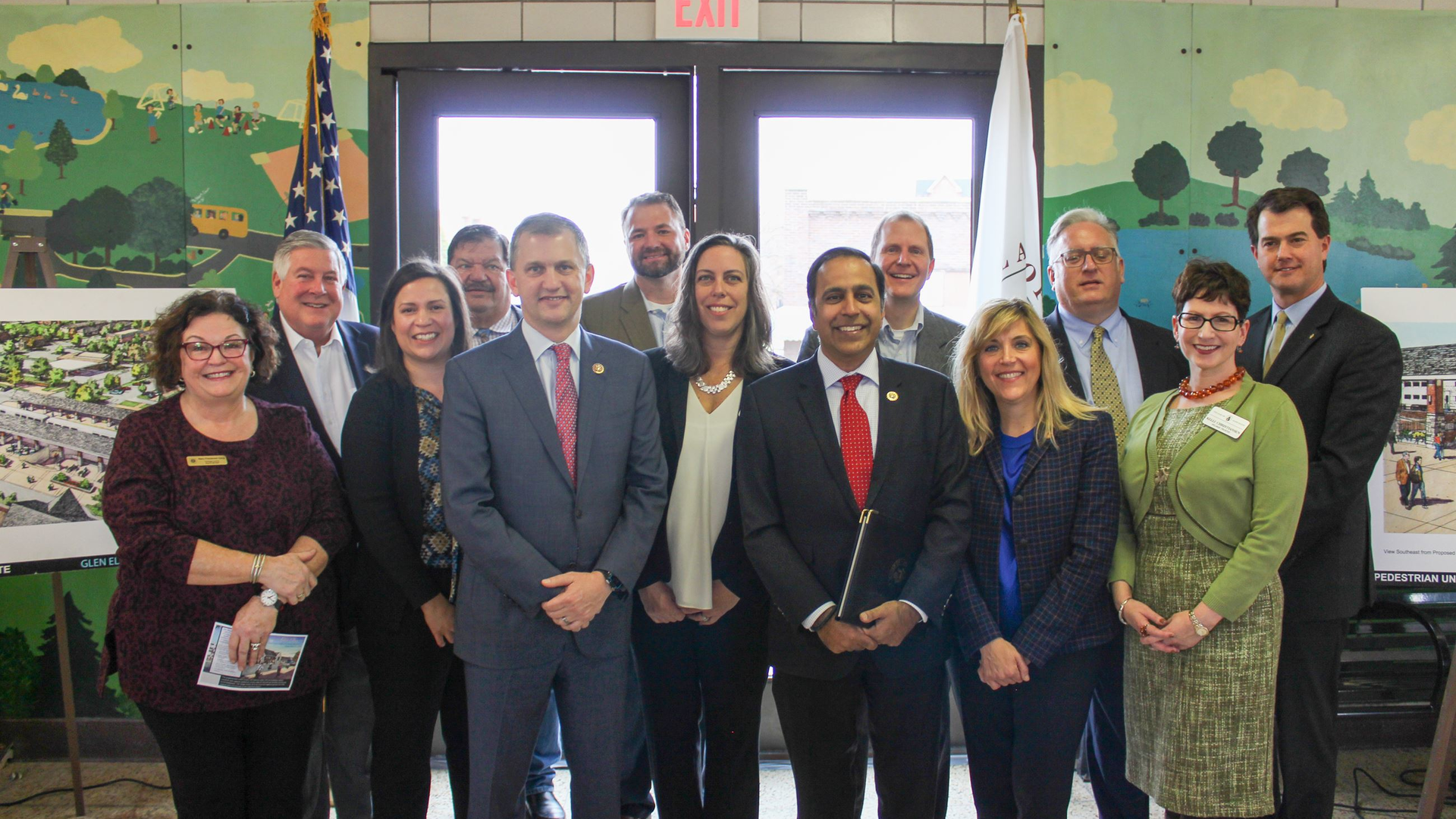U.S. Reps. Sean Casten, in grey suit near the front center, and Raja Krishnamoorthi, in red tie near front center, joined village and regional officials to celebrate a grant to build a new commuter rail station.