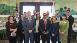 U.S. Reps. Sean Casten, in grey suit near the front center, and Raja Krishnamoorthi, in red tie near front center, joined village and regional officials to celebrate a grant to build a new commuter rail station.