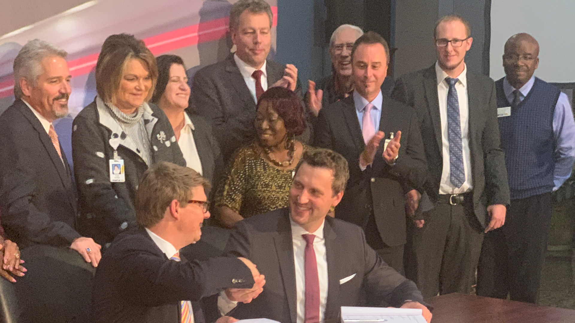 MARTA General Manager/CEO Jeffrey A. Parker, seated left, and Stadler US Inc. CEO Martin Ritter shake hands following a signing ceremony for a 254 new rail car contract.