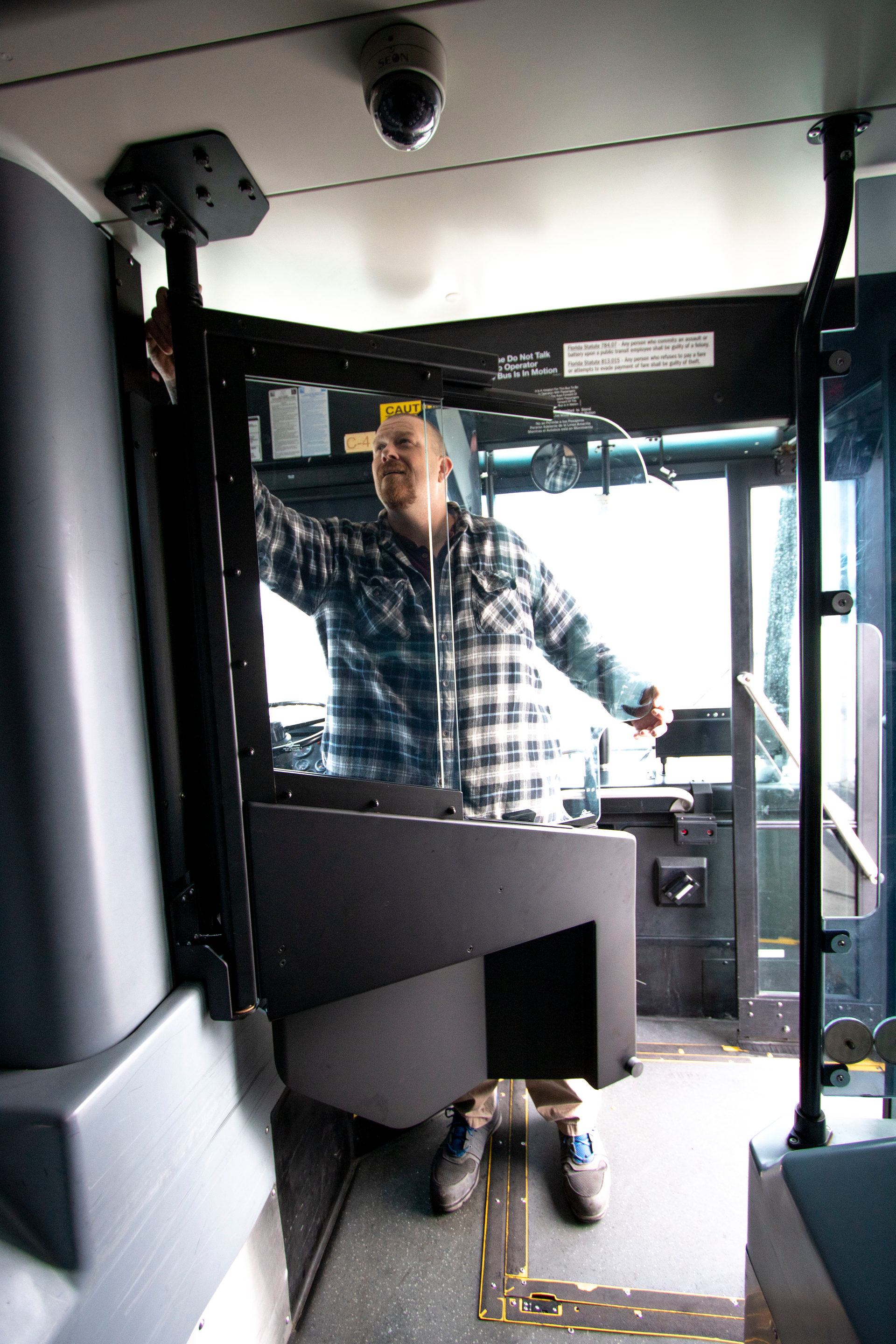 The safety shield has a sliding glass window, allowing for easier communication with passengers.