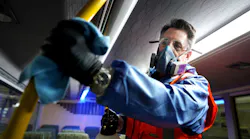 Wearing protective clothing due to the use of cleaning agents in a confined space, a Metrolinx crew member wipes down the inside of a GO bus in this March 2, 2020 image.