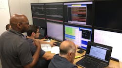 Engineers monitor performance of the communications between the train and the PTC system during a simulated train run in Metra&rsquo;s PTC lab.