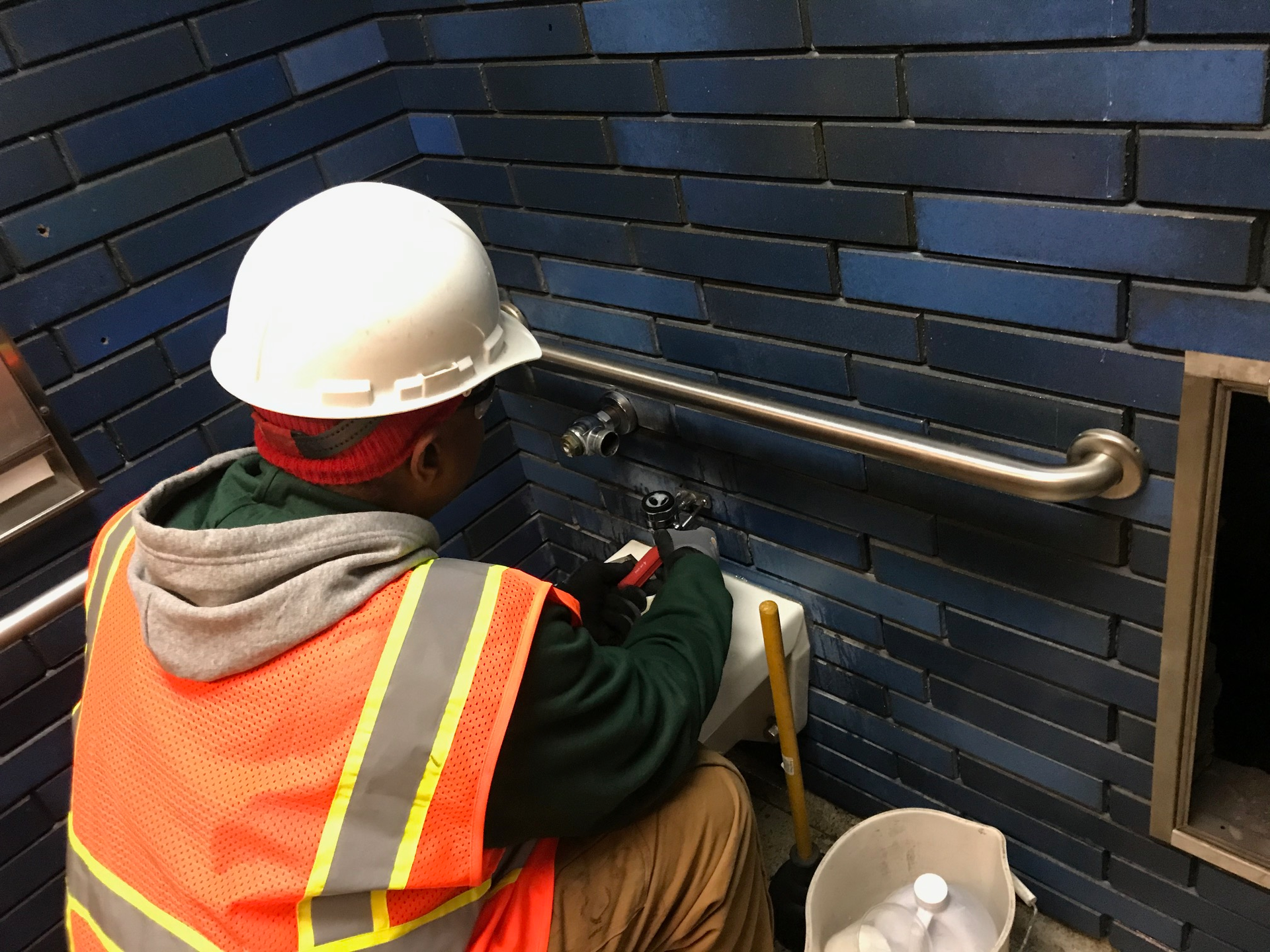 A BART crew member works on the demolition of the restroom at the 19th Street Station.