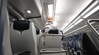 An NJ Transit employee cleans a train interior. Transit agency staff and riders will be required to wear face coverings while onboard vehicles and NJ Transit says it will continue its sanitization practices.