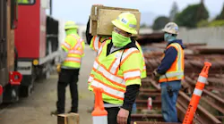 A worker carries wood blocks that are used in positioning a rail grinder. Contractor VSCE Inc.was on site at the Hayward maintenance yard to supervise and coordinate the work.