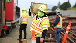 A worker carries wood blocks that are used in positioning a rail grinder. Contractor VSCE Inc.was on site at the Hayward maintenance yard to supervise and coordinate the work.
