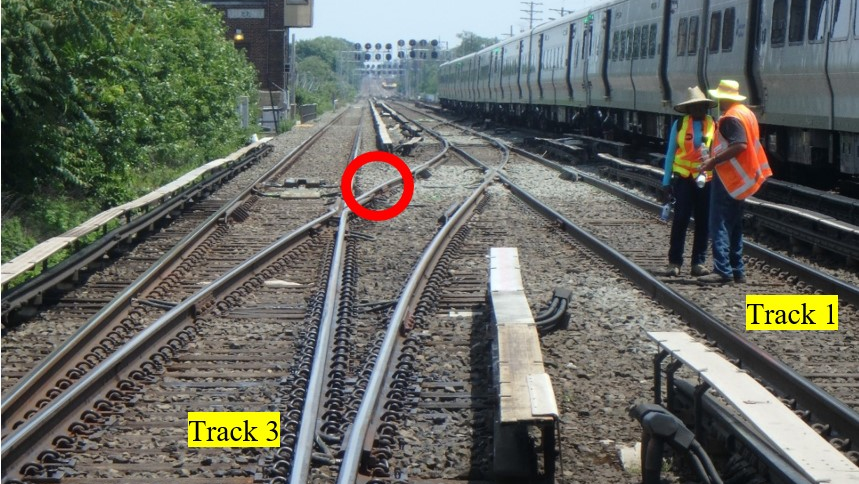 This photo illustration depicts the accident scene on June 11, 2017.The photo was taken at track level from the east end of the Queens Village Station. The point where the roadway worker was struck by the train is marked with the red circle.