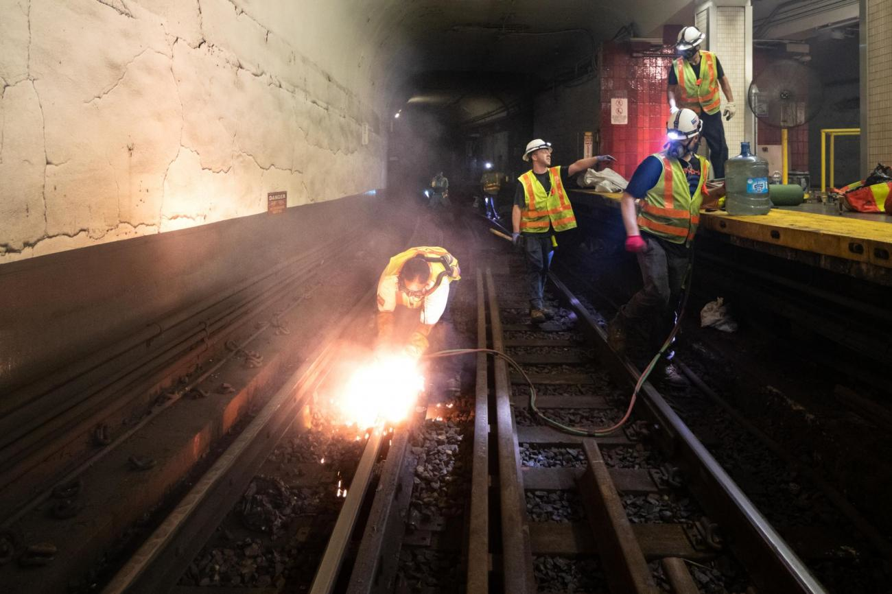A crew member uses a torch to cut rail near Bowdoin Station.