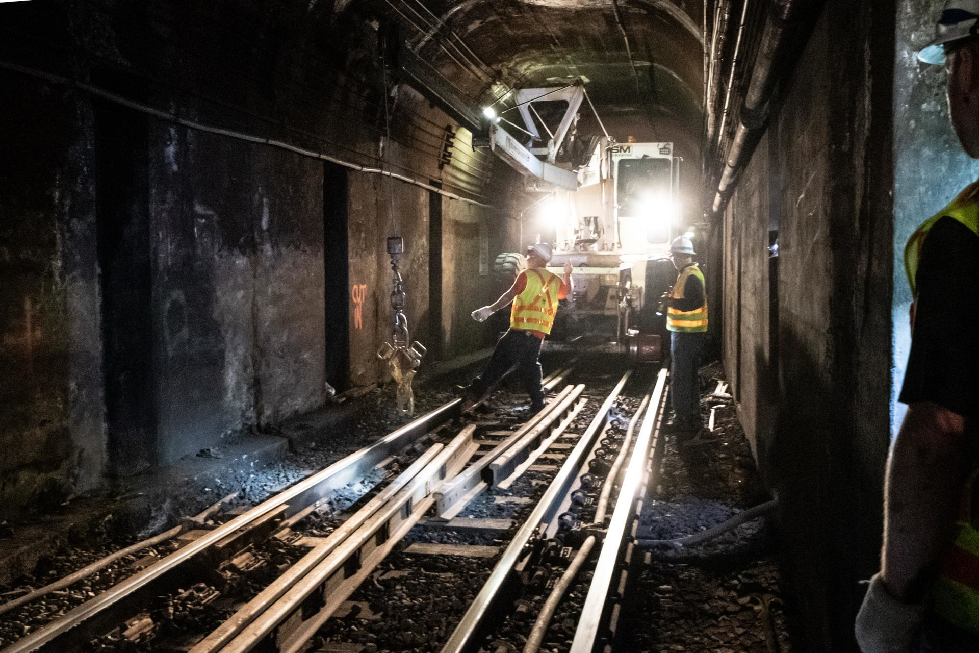 Crew members unload new rail from a swing loader for track replacement on the Blue Line near Bowdoin.