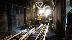 Crew members unload new rail from a swing loader for track replacement on the Blue Line near Bowdoin.