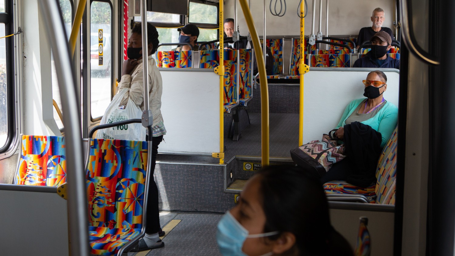 LOS ANGELES, CA - APRIL 29: Pedestrians wearing PPE ride the Westbound 33 Bus towards Venice in downtown Los Angeles on Wednesday, April 29, 2020 in Los Angeles, CA. For thousands of Metropolitan Transportation Authority bus drivers, going to work during a pandemic means spending hours in a confined space with strangers, wondering whether this will be the day they get sick. Ridership on Los Angeles County buses has fallen 65% since the pandemic started.