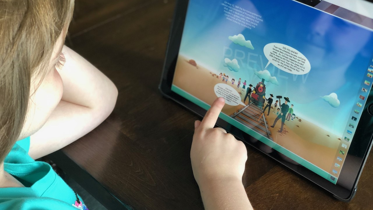 Our kid book reviewer reading her favorite page in the book marking the completion of the first transcontinental railroad.