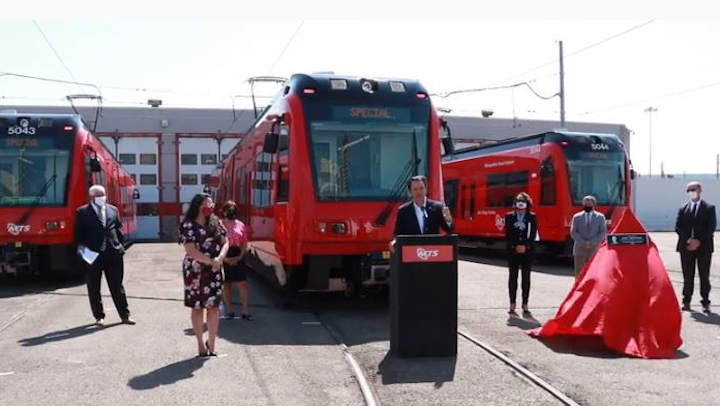 MTS Board Chair Nathan Fletcher, flanked by San Diego transportation leaders and California Transportation Commission Chair Hilary Norton (right of podium) delivers remarks at dedication ceremony for the final trolley car.