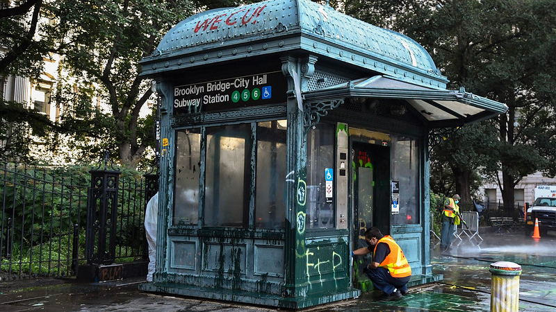 New York City Transit workers clean station entrances and an elevator at the Brooklyn Bridge-City Hall station in July 2020 - hours after the Occupy City Hall encampment was dispersed.