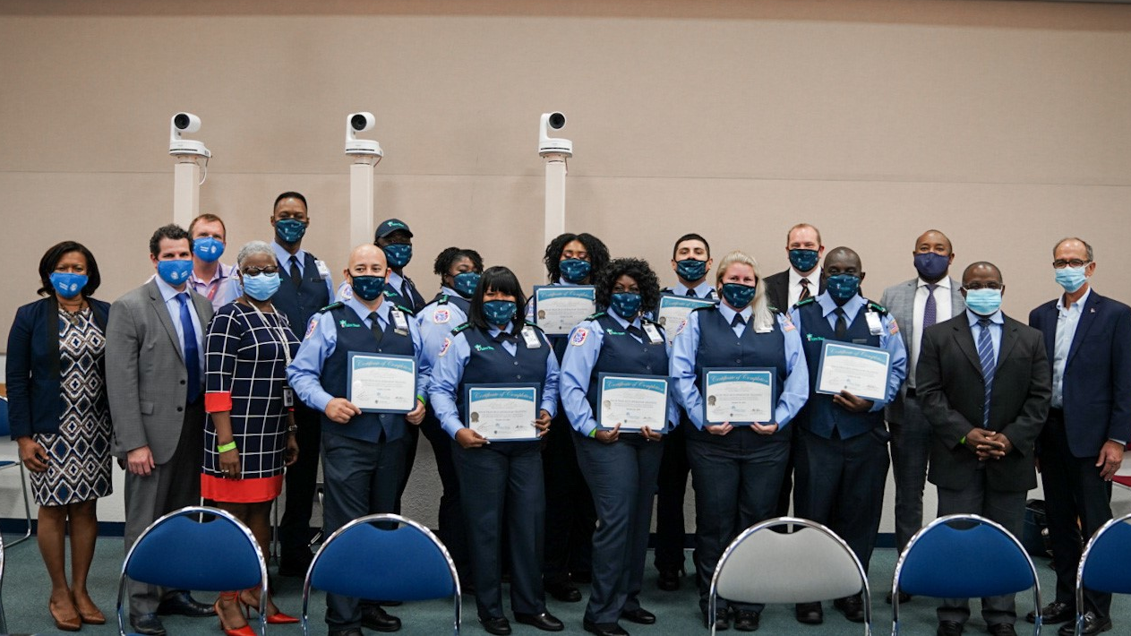 County leadership poses with bus operator graduates: Marvin Alvarez, Verna Baker, Shalona Bennette, Tony Hampton, Molene Innocent, Tammy Jackson, Wallace James, Carlos Martinez, Alfreda McCoy and Neil McPherson