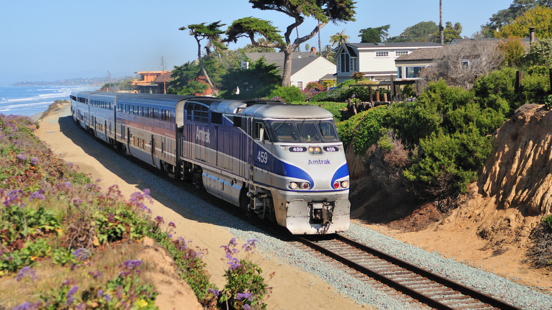 An Amtrak train traveling along tracks that are situated on the Del Mar Bluffs along the LOSSAN Corridor in southern California.