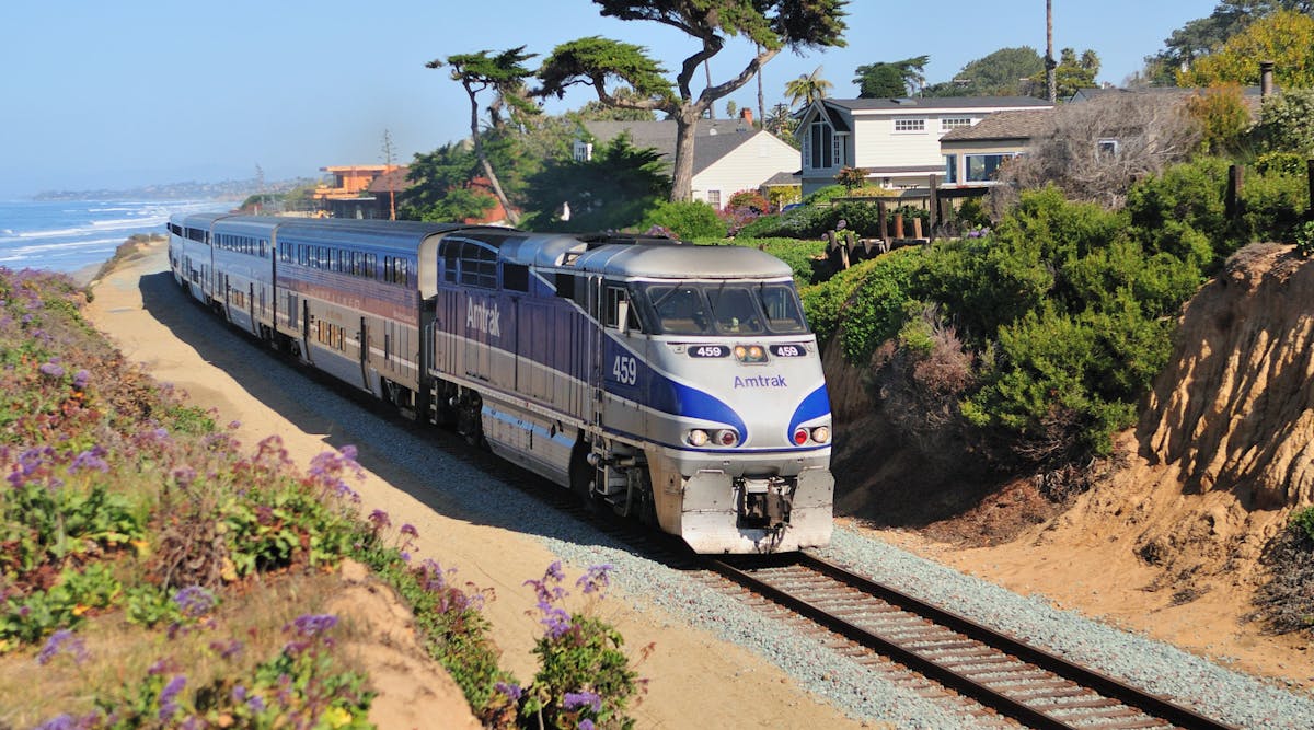 An Amtrak train traveling along tracks that are situated on the Del Mar Bluffs along the LOSSAN Corridor in southern California.