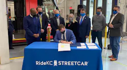 City Manager for Kansas City, Mo., Brian David Platt, seated, signs the FFGA finalizing the $174-million in funds through the CIG Program for the KC Streetcar Main Street extension.
