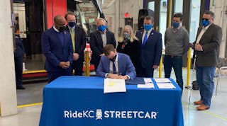 City Manager for Kansas City, Mo., Brian David Platt, seated, signs the FFGA finalizing the $174-million in funds through the CIG Program for the KC Streetcar Main Street extension.