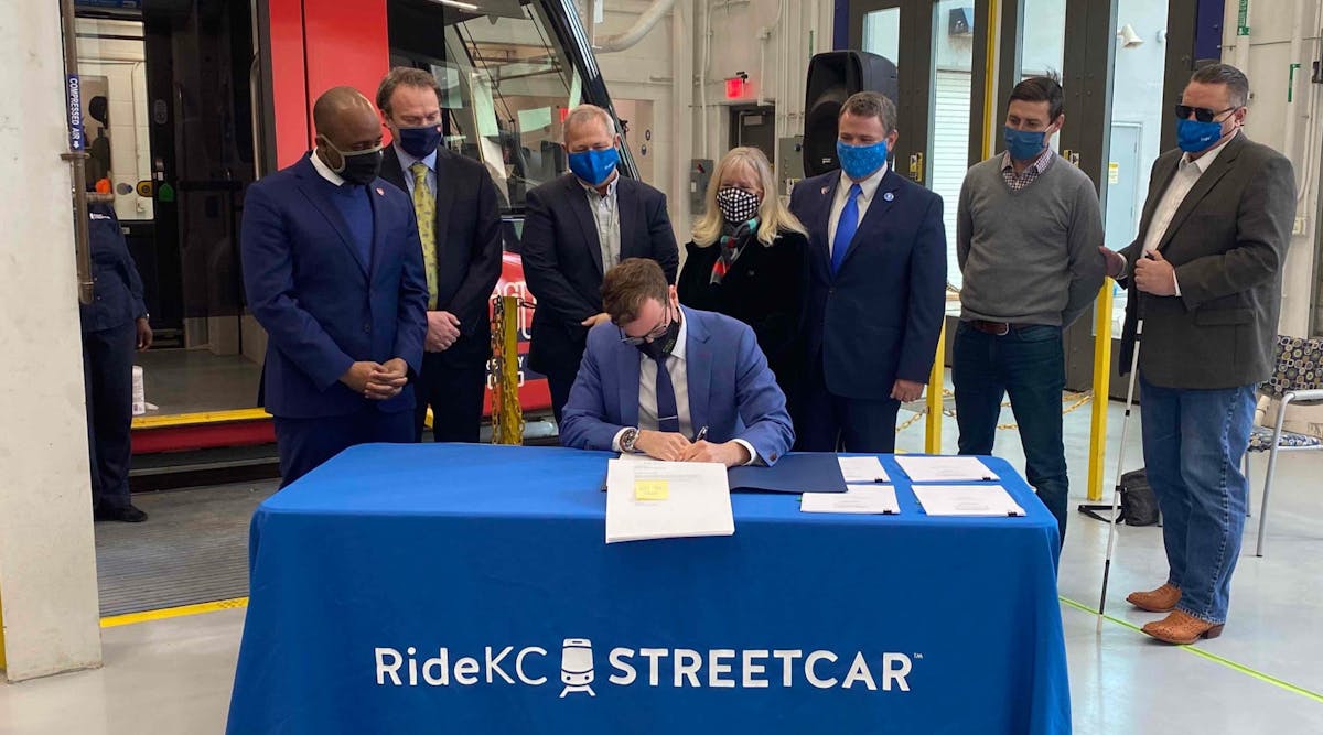 City Manager for Kansas City, Mo., Brian David Platt, seated, signs the FFGA finalizing the $174-million in funds through the CIG Program for the KC Streetcar Main Street extension.