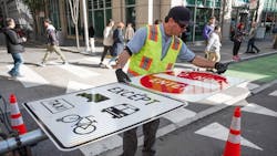 A crew member installs new signage on Market Street in January 2020. A crew member installs new signage on Market Street in January 2020.