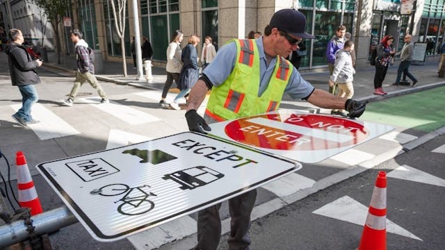 A crew member installs new signage on Market Street in January 2020.