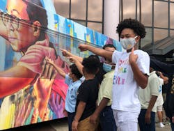 New Orleans 7th grader, Dontay Allen at the unveiling of the public arts bus where he is featured.