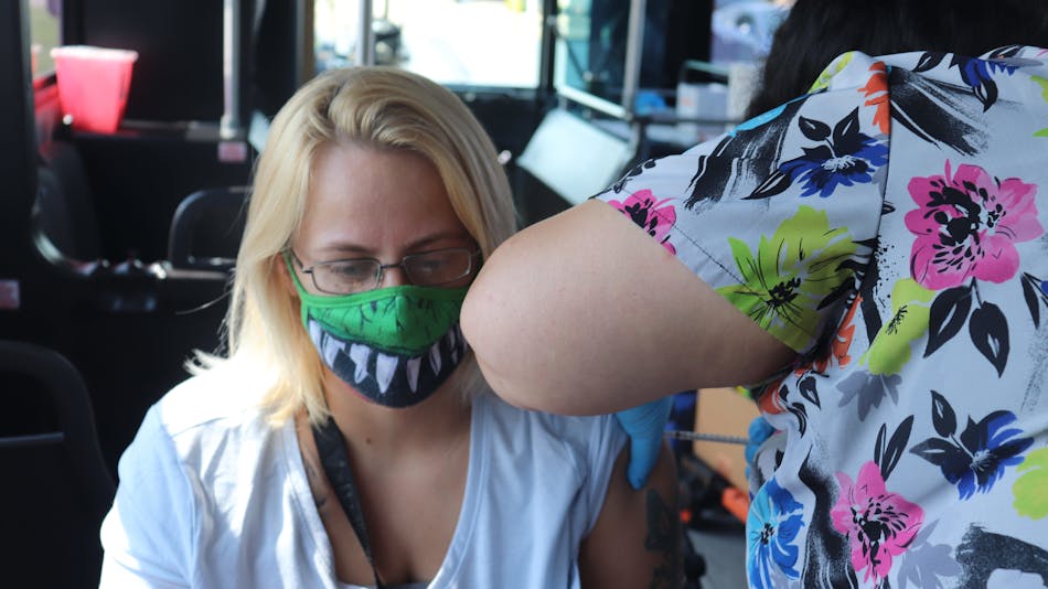 Michelle Cassidy receives the Pfizer-BioNTech coronavirus vaccine Wednesday during the Stark County Health Department&apos;s mobile clinic aboard a Stark Area Regional Transit Authority bus.