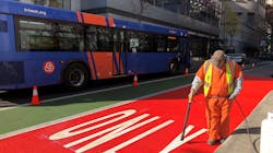 PBOT crews apply red paint to a bus-only lane on SW Main Street.
