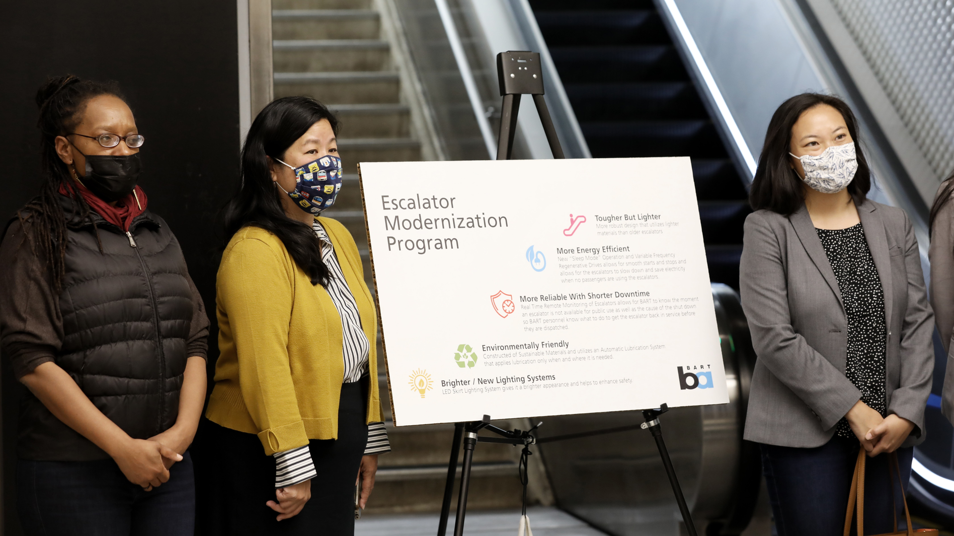 BART Board member Lateefah Simon stands next to infographic detailing benefits of new escalators coming to Market Street stations at the press conference on Aug. 31, 2021, at Powell Station.