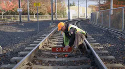 A TriMet rail inspector sets up a call board at one end of a work zone. Call boards are one safety component utilized by track inspectors when working on or near live track.