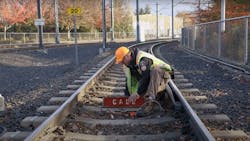 A TriMet rail inspector sets up a call board at one end of a work zone. Call boards are one safety component utilized by track inspectors when working on or near live track.