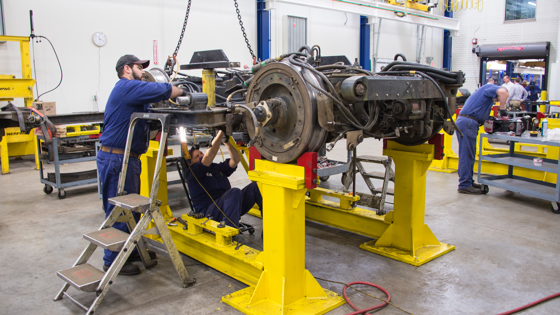 In this image from 2015, Metro Transit Electro-Mechanic Technicians service the mechanism that moves a train along the tracks.