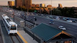 A Denver RTD light-rail train approaches Orchard Station next to I-25.