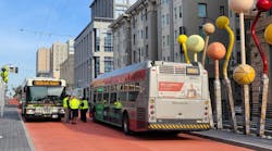 Staff measure passing distances between a Golden Gate Transit bus and a Muni bus at the Geary-O&apos;Farrell BRT stop, where public artwork is being installed.