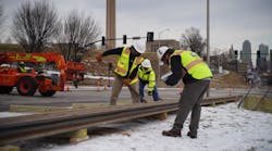 Workers lay the rail in the staging area at 27th &amp; Main St.