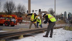 Workers lay the rail in the staging area at 27th &amp; Main St.