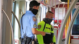 An MTS transit security officer in bright yellow and an Inter-Con security contract officer in blue on a joint patrol.