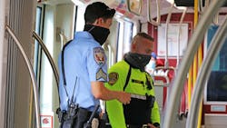 An MTS transit security officer in bright yellow and an Inter-Con security contract officer in blue on a joint patrol. An MTS transit security officer in bright yellow and an Inter-Con security contract officer in blue on a joint patrol.