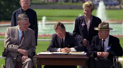 President George Bush signs into law the Americans with Disabilities Act of 1990 on the South Lawn of the White House. L to R, sitting: Evan Kemp, Chairman, Equal Employment Opportunity Commission, Justin Dart, Chairman, President's Committee on Employment of People with Disabilities. L to R, standing: Rev. Harold Wilke and Swift Parrino, Chairperson, National Council on Disability, 07/26/1990.