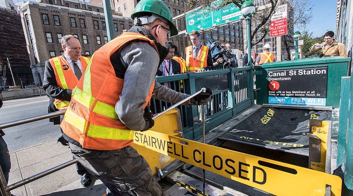 An MTA worker demonstrates how retractable stairwell covers are deployed in this October 2017 image. The covers are one of several flood mitigation devices MTA purchased and installed following Superstorm Sandy in 2012.