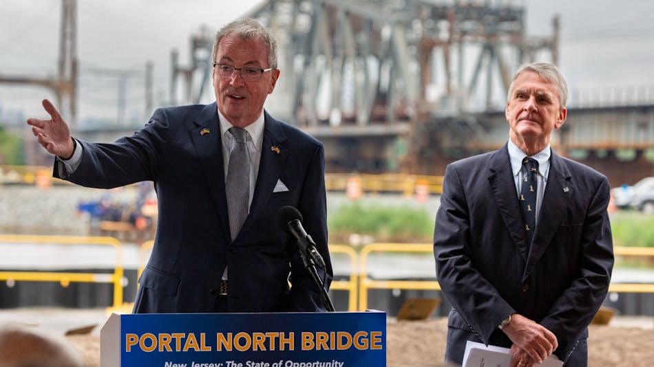 New Jersey Gov. Phil Murphy and NJ Transit President and CEO Kevin S. Corbett at the groundbreaking event held Aug. 1 for the Portal North Bridge, which can be seen in the background.