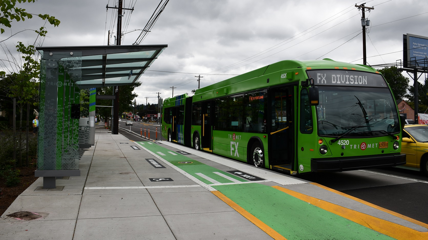 A 60-foot articulated bus branded for use on the FX2-Division route is shown at one of the new stations.