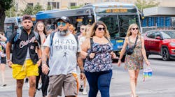 Attendees of Austin City Limits Music Festival make their way past CapMetro buses.