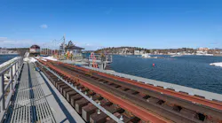 Top deck of the south bascule spans over the channel. Workers have installed new railroad ties and track on the bridge.