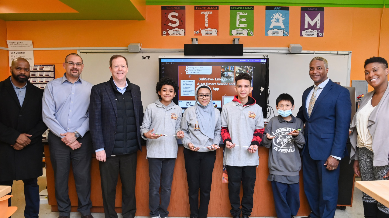 The four student finalists of the annual Samsung Solve for Tomorrow STEM competition, alongside their teacher Jessica Abrams and MTA leaders.