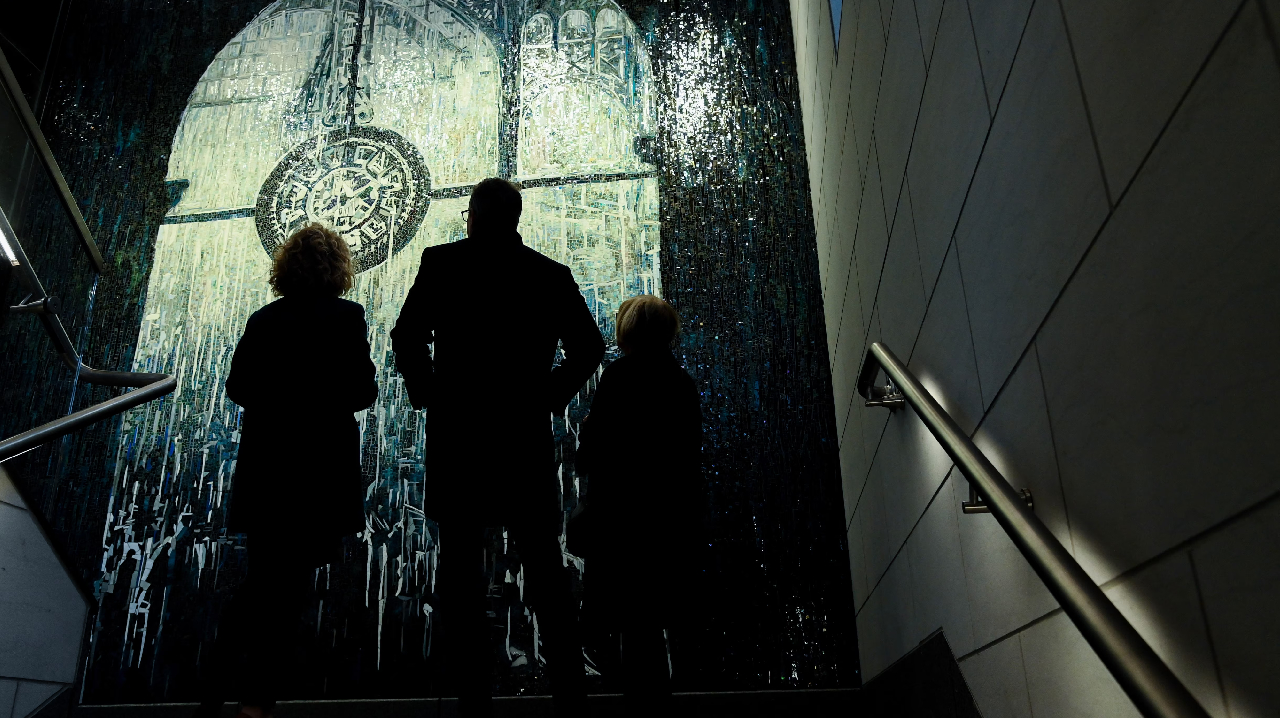 Residents looking at The Time Telling art piece up at Penn Station.