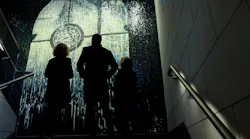 Residents looking at The Time Telling art piece up at Penn Station.