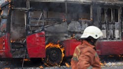 A bus burning from a fire with fire department on site. A bus burning from a fire with fire department on site.