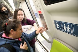 Two blind and low vision attendees learn how to use the emergency intercom inside a Fleet of the Future train. Two blind and low vision attendees learn how to use the emergency intercom inside a Fleet of the Future train.